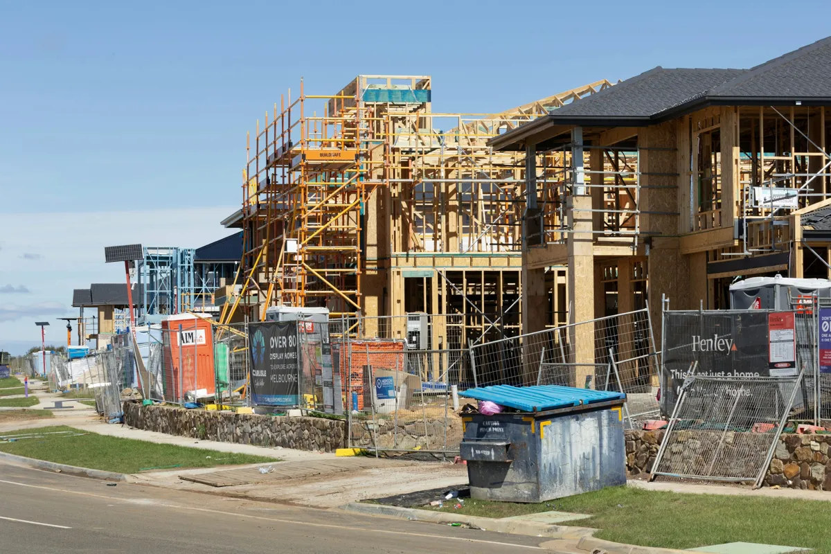 Low-rise residential buildings under construction, showing wood framing and scaffolding